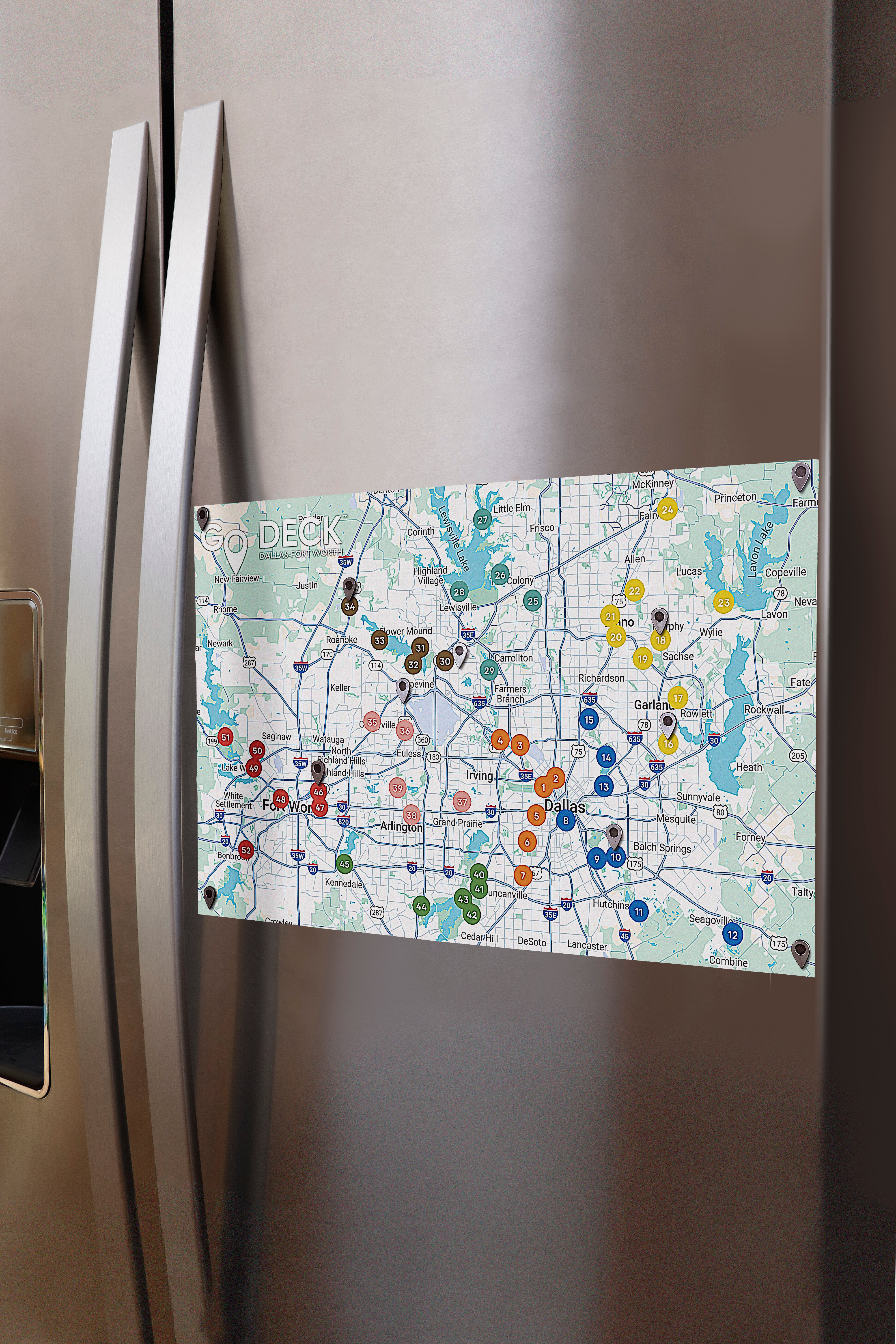 Map magnet on a refrigerator door with various colored pins.