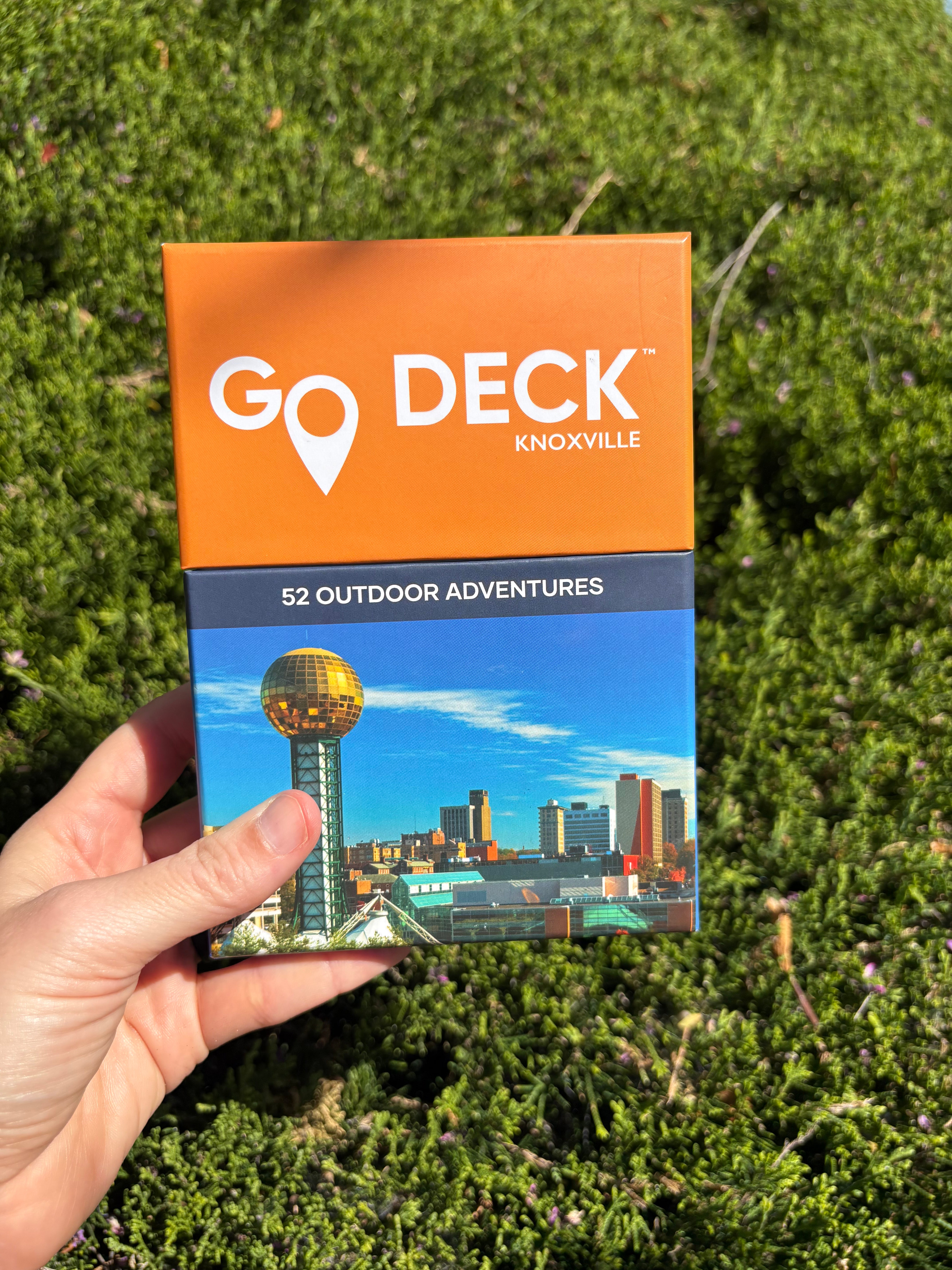 Go Deck Knoxville outdoor adventure guide held in front of green foliage